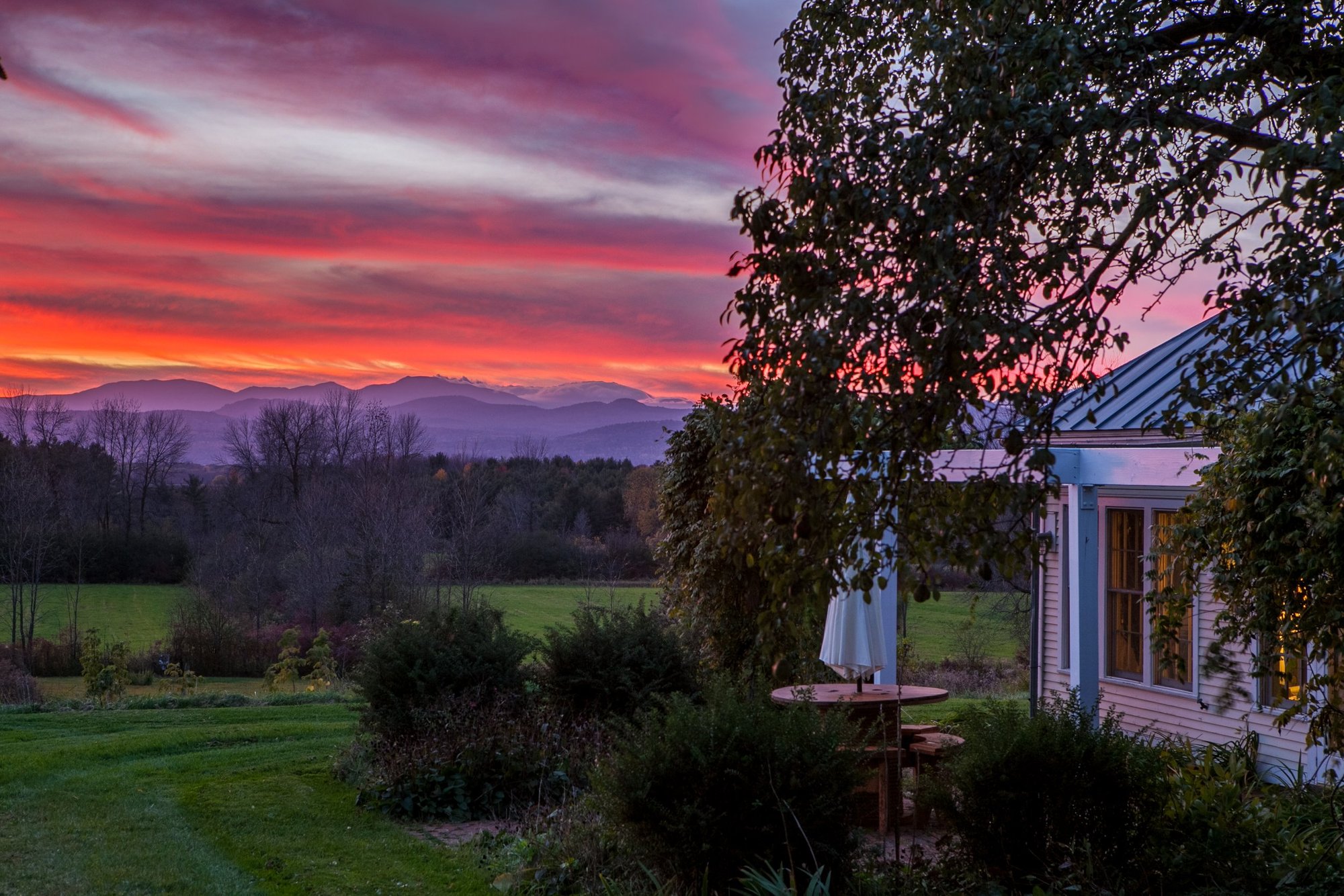 Vivid pink and purple sunset over the Adirondacks seen from the guest house patio.